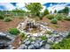 Backyard with a decorative rock waterfall feature, mature landscaping, and a tranquil ambiance at 3855 Old Oaks St, Castle Rock, CO 80104