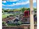 Beautiful backyard featuring a rock waterfall, lush landscaping, and a white picket fence at 3855 Old Oaks St, Castle Rock, CO 80104