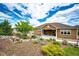 Rear exterior view showcases a well-maintained home with landscaped backyard, waterfall, and covered patio at 3855 Old Oaks St, Castle Rock, CO 80104