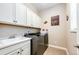 Functional laundry room with washer, dryer, sink, and upper cabinets at 3855 Old Oaks St, Castle Rock, CO 80104