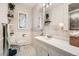 Bathroom with patterned wallpaper, built-in shelves, and large vanity at 1748 S Locust St, Denver, CO 80224