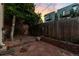 Backyard with brick-lined patio, wooden fence, and a mature shade tree at 408 E 1St Ave, Denver, CO 80203