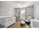 Bedroom with crib, rocking chair, and neutral decor at 4841 S Picadilly Ct, Aurora, CO 80015