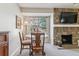 Cozy dining area with stone fireplace, round table, chairs, and an exterior view through a window at 4070 S Atchison Way # 203, Aurora, CO 80014