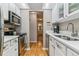 Bright kitchen with stainless steel appliances, wooden floors, and white cabinets and countertops at 4070 S Atchison Way # 203, Aurora, CO 80014