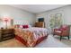 Cozy main bedroom with a floral-patterned bed, TV, side tables, and a window for ample natural light at 4070 S Atchison Way # 203, Aurora, CO 80014