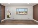 Bright living area featuring wood-look flooring, a modern door, and a large window with neighborhood views at 2840 Cottonwood Dr, Denver, CO 80221