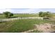 Aerial shot of a large green fenced in pasture with a gate, bench, and mature trees at 1788 Shoshone Trl, Elizabeth, CO 80107