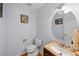 Cozy half bathroom featuring a vanity sink, toilet with decorated seashells, and decorative mirror at 19118 E Grand Cir, Aurora, CO 80015