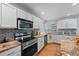 Well-equipped kitchen with stainless appliances, granite countertops, tile backsplash, and a modern gas range at 19118 E Grand Cir, Aurora, CO 80015