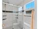 Modern tiled shower with a glass door, sleek fixtures, and a built-in shelf at 19118 E Grand Cir, Aurora, CO 80015