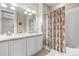 Bathroom featuring a bathtub with shower curtain, double sinks, and cabinets at 6174 Flattop St, Golden, CO 80403