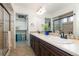 Elegant bathroom with double sinks, a walk-in shower, and a separate closet at 5480 Danube St, Denver, CO 80249