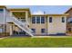 Rear exterior of home with staircase leading to the covered deck overlooking the lush lawn at 21855 E Idyllwilde Dr, Parker, CO 80138