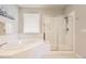 Bright bathroom featuring a soaking tub, a glass-enclosed shower, and white tile, creating a clean and serene space at 21855 E Idyllwilde Dr, Parker, CO 80138