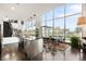 Open dining area with floor-to-ceiling windows showcasing city views next to a modern kitchen with island and breakfast bar at 55 W 12Th Ave # 608, Denver, CO 80204