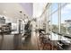 Bright, open-concept living space with a modern kitchen, dining area, and staircase featuring floor-to-ceiling windows at 55 W 12Th Ave # 608, Denver, CO 80204