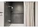 Modern bathroom shower with sleek, dark tiling and chrome fixtures at 55 W 12Th Ave # 608, Denver, CO 80204