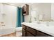 Bathroom featuring a tub shower with turquoise curtain, sink vanity, and framed mirror at 6041 N Orleans St, Aurora, CO 80019