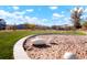 Scenic common area featuring lush green lawns, a sandbox with decorative boulders, and picturesque walking paths at 6041 N Orleans St, Aurora, CO 80019