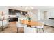 Open concept view of dining room featuring wood table, kitchen, and adjacent living room at 6041 N Orleans St, Aurora, CO 80019