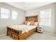 Cozy bedroom with warm wood furniture, bright natural light from two windows, and soft carpet flooring at 6041 N Orleans St, Aurora, CO 80019