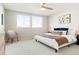 Bright bedroom with a plush chair, ceiling fan, neutral decor, and natural light from the windows at 6041 N Orleans St, Aurora, CO 80019