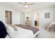 Comfortable bedroom featuring a ceiling fan, neutral decor, and an open doorway to the ensuite bathroom at 6041 N Orleans St, Aurora, CO 80019