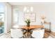 Stylish dining room with a round wooden table, white chairs, and a modern chandelier at 6041 N Orleans St, Aurora, CO 80019