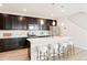 Contemporary kitchen with dark wood cabinets, stainless steel appliances, and a large island at 6041 N Orleans St, Aurora, CO 80019