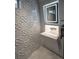 Unique bathroom features an illuminated mirror and a wall with textured geometric tiles at 1175 S Jackson St, Denver, CO 80210
