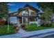 Contemporary two-story home with a modern design, balcony, manicured lawn, and walkway with landscape lighting at 1175 S Jackson St, Denver, CO 80210