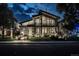 Night view of a stylish modern home with a balcony, manicured lawn, and illuminated walkway and landscaping at 1175 S Jackson St, Denver, CO 80210