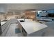 Modern kitchen with sleek white counters, island with dining area, and open shelving at 1175 S Jackson St, Denver, CO 80210