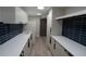 Kitchenette features sleek white countertops, navy tile backsplash, and modern cabinetry at 1175 S Jackson St, Denver, CO 80210