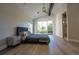 Bright main bedroom with wood floors, slider to balcony, and ensuite bathroom at 1175 S Jackson St, Denver, CO 80210
