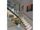 Elegant staircase with glass railings, modern lighting, and artwork adding a touch of sophistication at 1175 S Jackson St, Denver, CO 80210