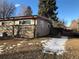 View of the home's backyard showing a partially snow-covered lawn and fencing at 6139 Broadway S, Littleton, CO 80121