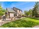 Beautifully landscaped backyard with patio, seating, lush green lawn, and mature trees at 1825 Cooper Ct, Castle Rock, CO 80109