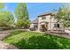 Expansive backyard with patio, dining area, lush lawn, mature trees, and privacy fence at 1825 Cooper Ct, Castle Rock, CO 80109