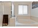 Bright bathroom showcasing a bathtub with tiled surround, glass shower and window offering natural light at 1825 Cooper Ct, Castle Rock, CO 80109