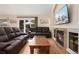 Living room with leather sofas, a fireplace, and an outdoor view from the large sliding door at 1825 Cooper Ct, Castle Rock, CO 80109