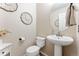 Cozy powder room featuring a pedestal sink, toilet, and decorative wall art at 1825 Cooper Ct, Castle Rock, CO 80109