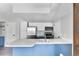 Kitchen island featuring stainless steel appliances, white cabinets, and bright white countertops at 1740 S Ammons St # C, Lakewood, CO 80232