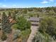 Overhead view of the house on a large lot with mature trees, lush lawn, and a two car garage at 7605 E Windlawn Way, Parker, CO 80134