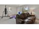 Finished basement with comfortable seating, fitness equipment, and walk-out to yard at 7605 E Windlawn Way, Parker, CO 80134
