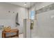 Beautiful bathroom featuring glass shower with gold hardware, marble tile, and a wood bench at 7605 E Windlawn Way, Parker, CO 80134