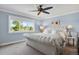Inviting bedroom featuring a king bed, blue walls, white trim, a ceiling fan, and large window at 7605 E Windlawn Way, Parker, CO 80134