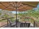Relaxing deck space with outdoor seating, an umbrella for shade, and views of the green landscape at 7605 E Windlawn Way, Parker, CO 80134