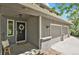 Charming front porch featuring a black door with wreath, gray siding, and an attached two-car garage at 7605 E Windlawn Way, Parker, CO 80134